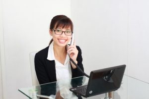 電話・パソコンで応対する女性:写真画像